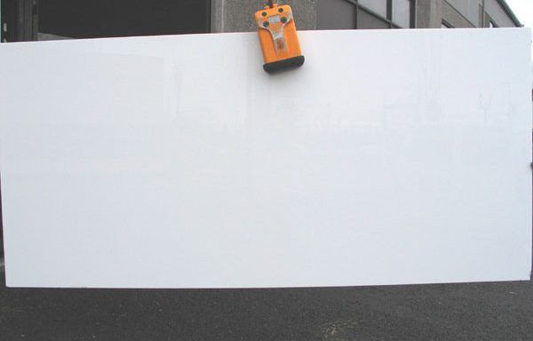 A large white board is being lifted by a crane.