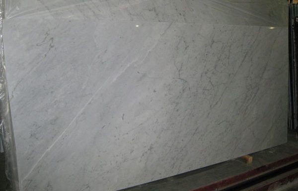 A large white marble slab is sitting on top of a concrete floor.