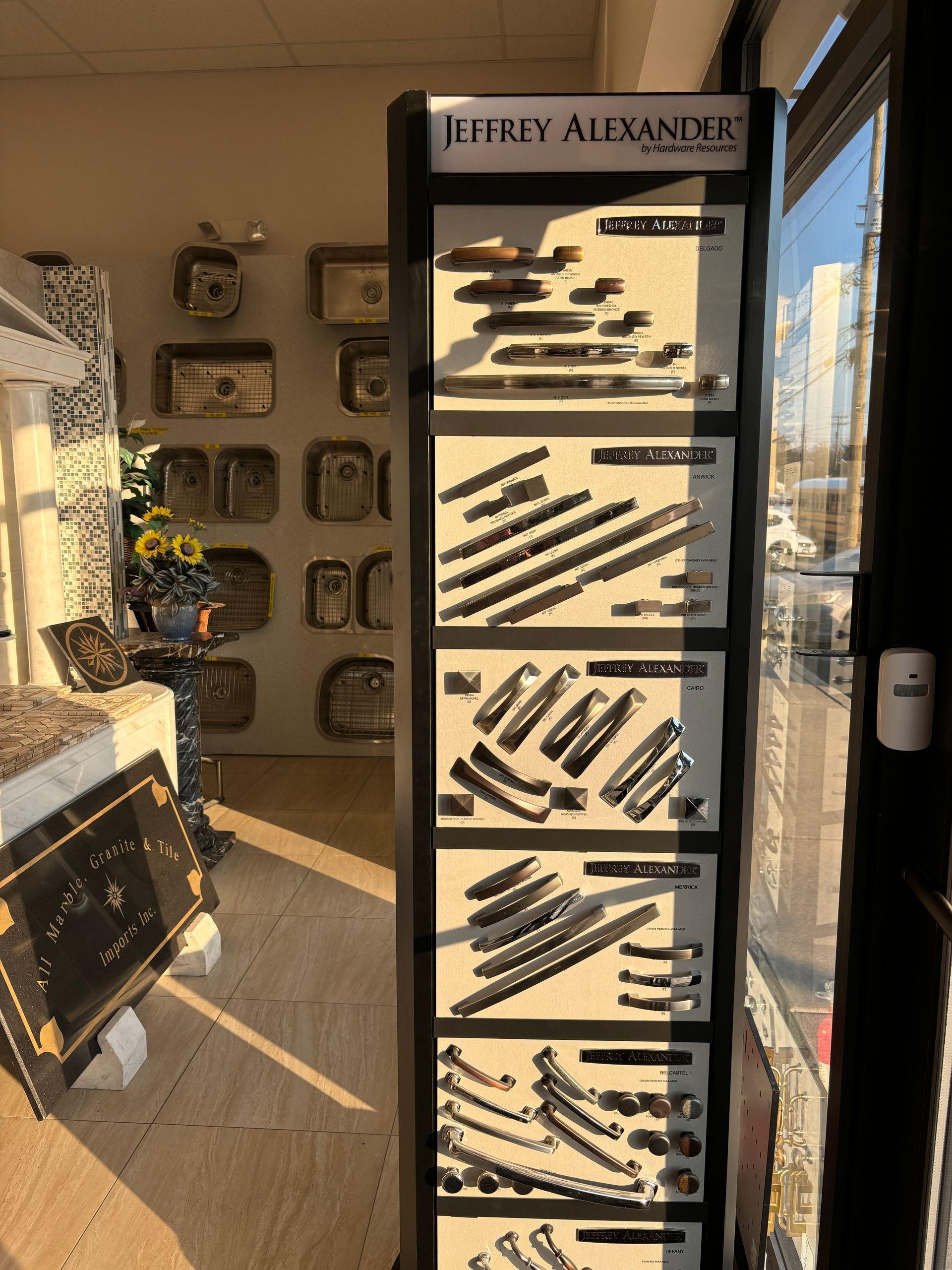 A display case filled with different types of handles and knobs in a store.