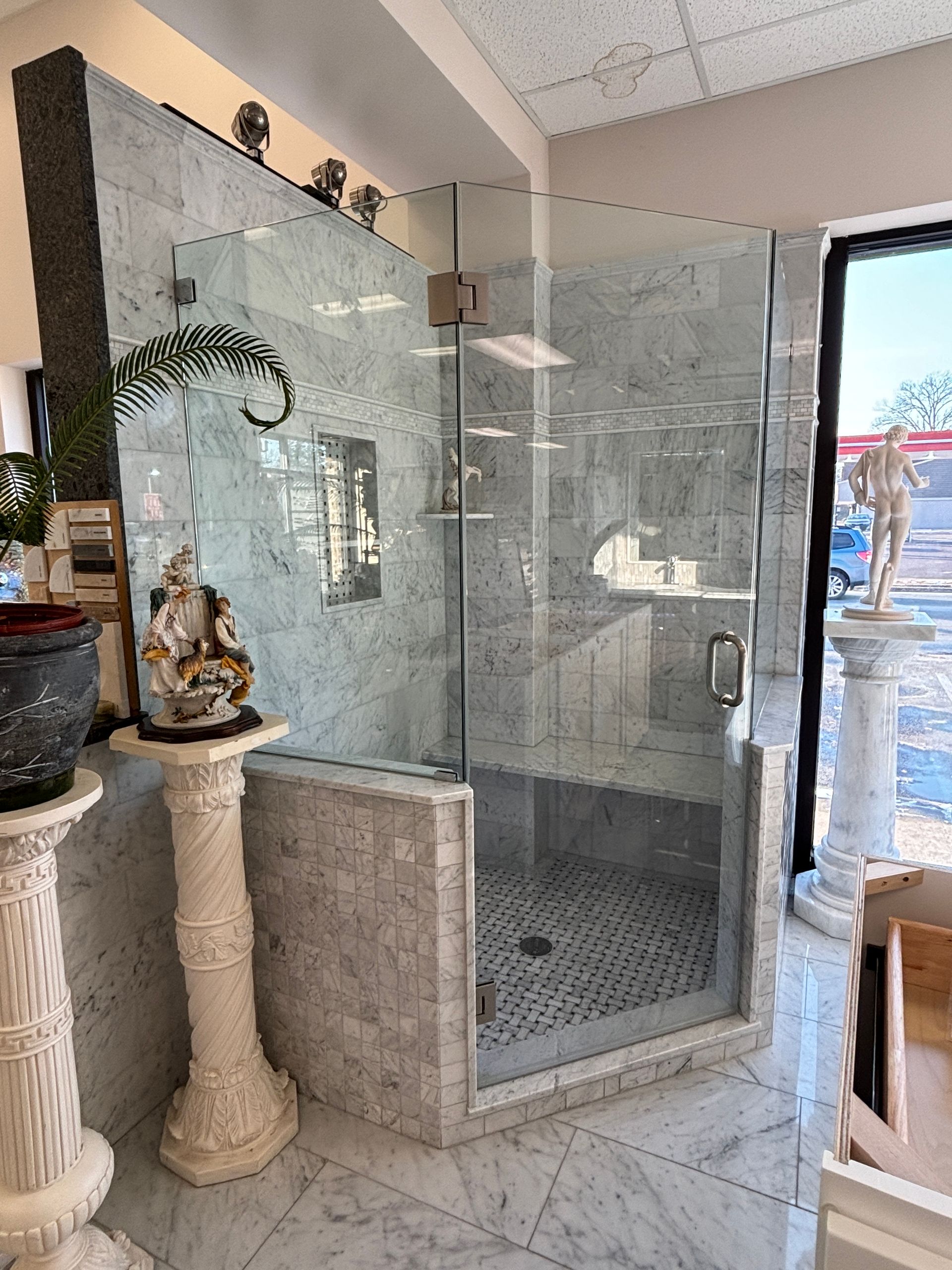 A bathroom with a walk in shower with a glass door.