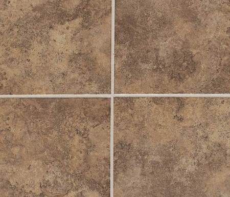 A close up of a brown tile floor with white grout.