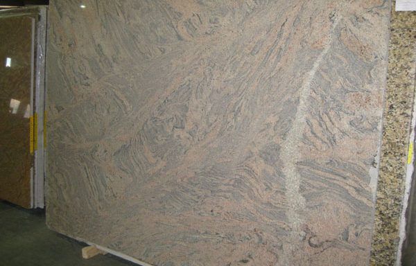 A large granite slab is sitting on top of a wooden pallet.