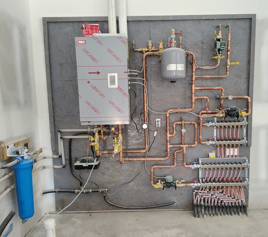 A wall with a lot of pipes and a box that says ' stainless steel ' on it