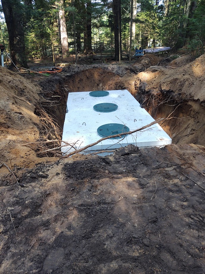 A septic tank is being installed in a hole in the ground.