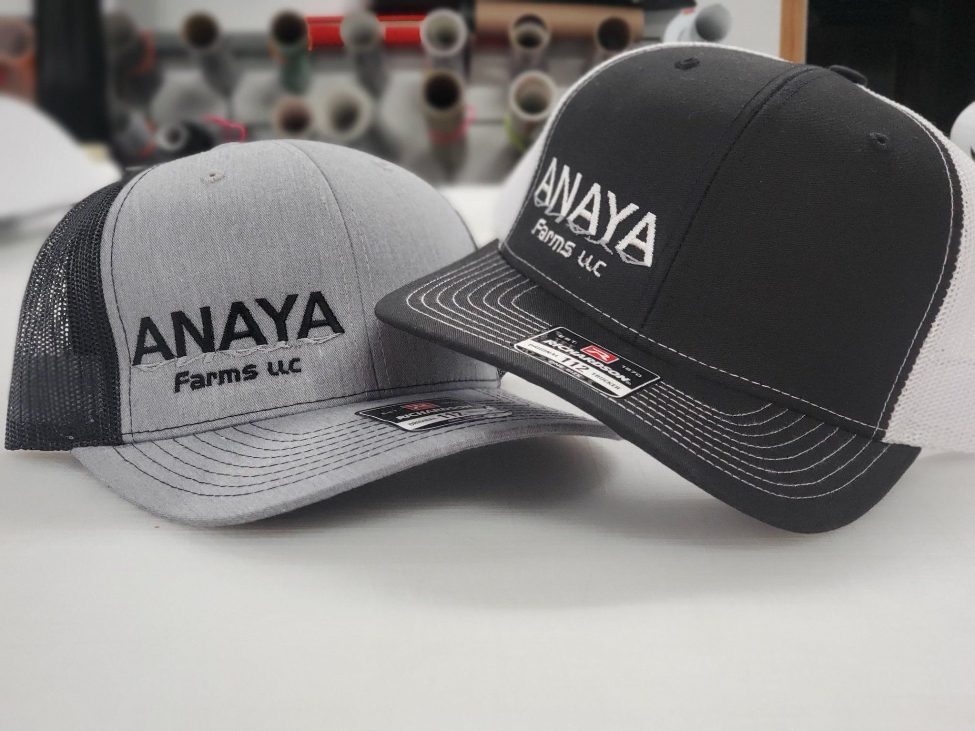 Two hats with the word anaya on them are sitting on a table.