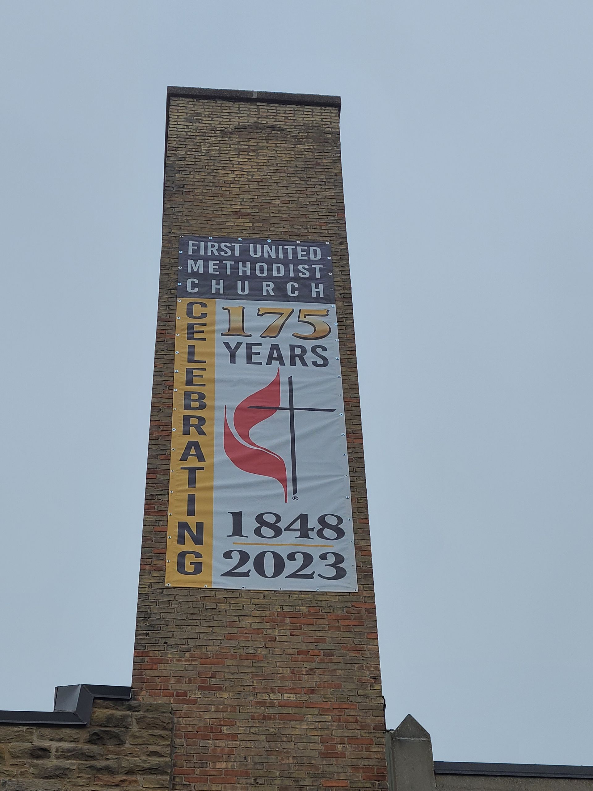 A brick chimney with a banner on it that says 175 years celebrating 1848 2023