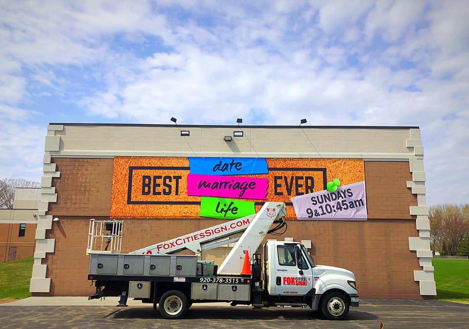A truck is parked in front of a building that says best marriage ever