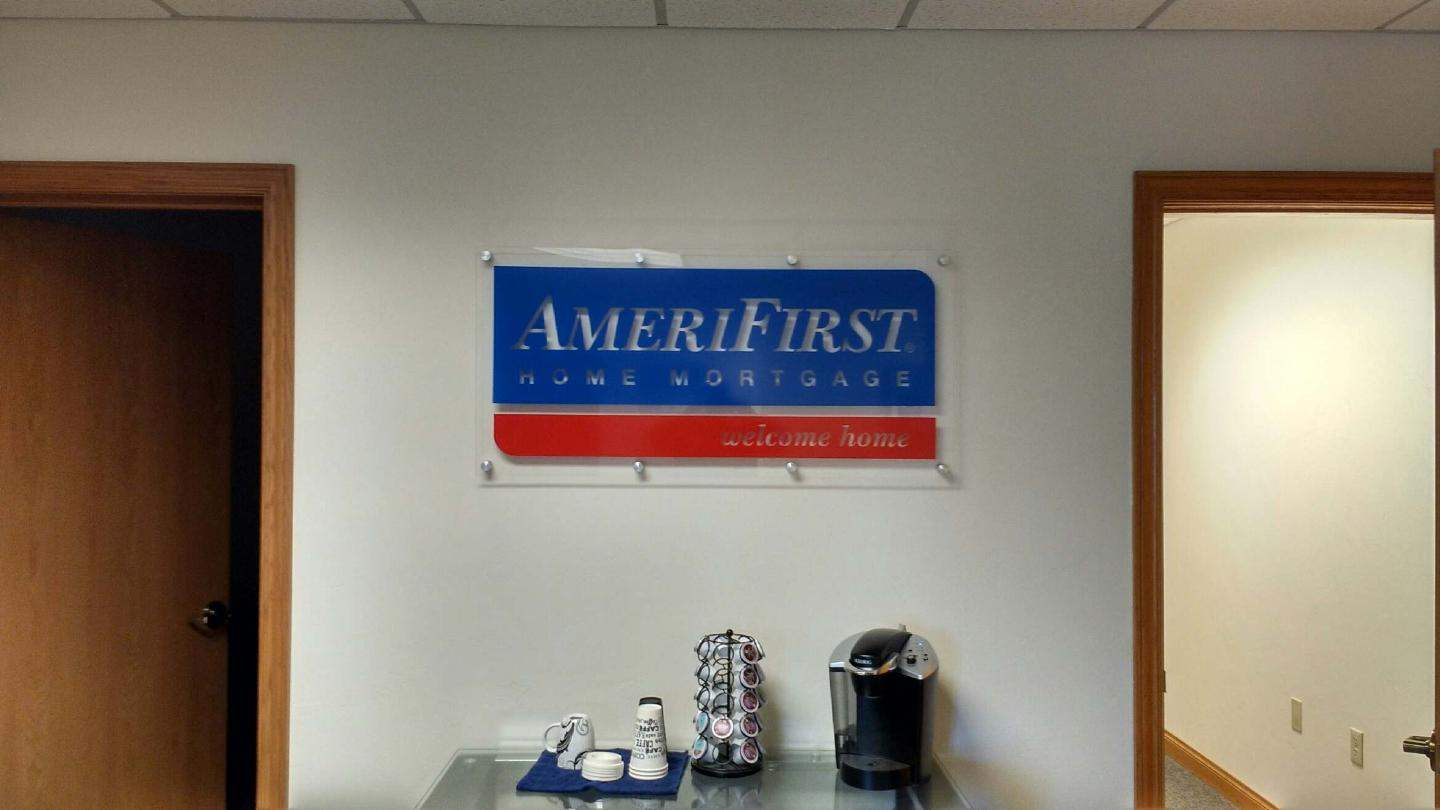 A sign that says amerifirst hangs on a wall