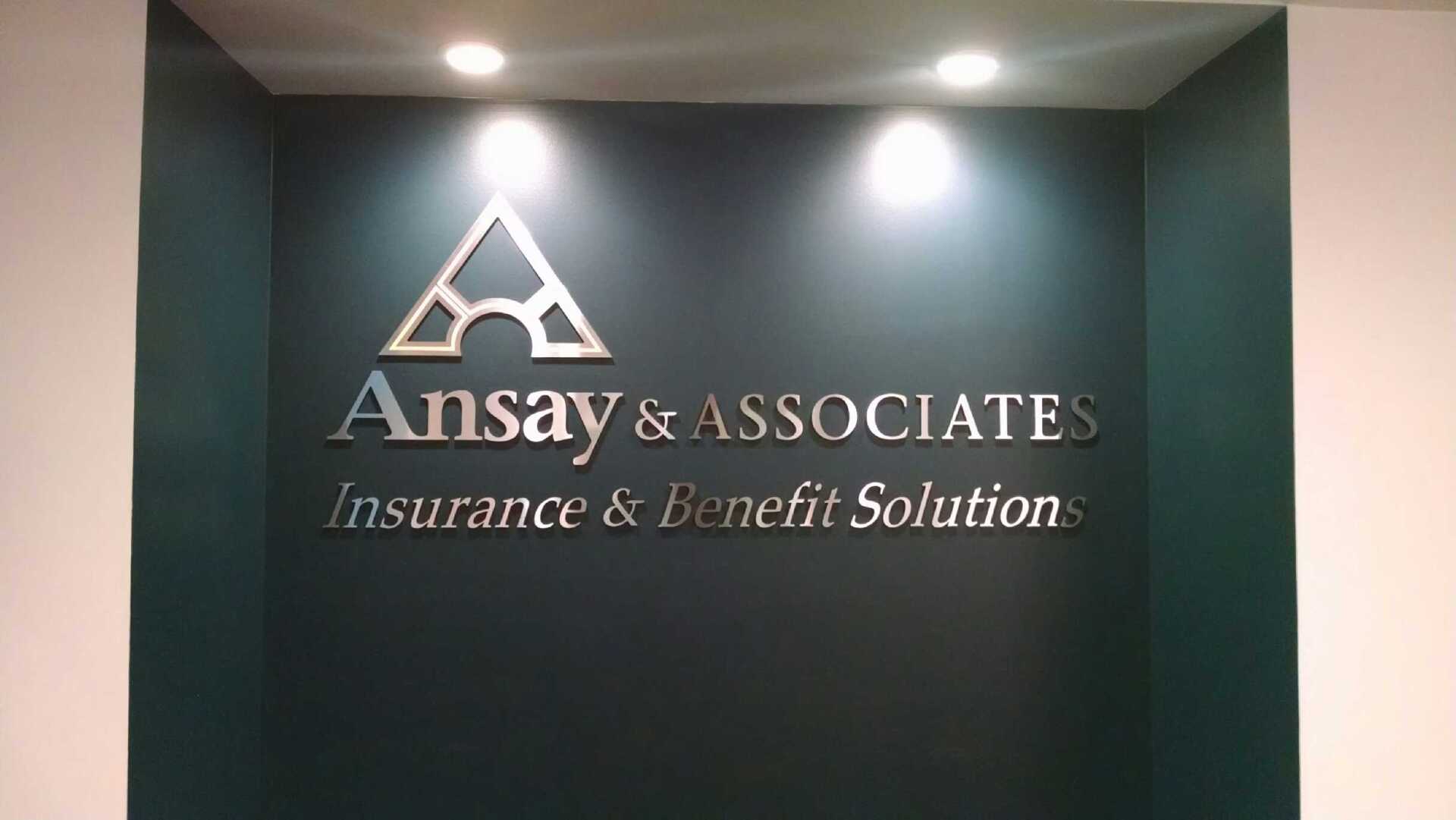 A sign on a wall that says ansay & associates insurance & benefit solution