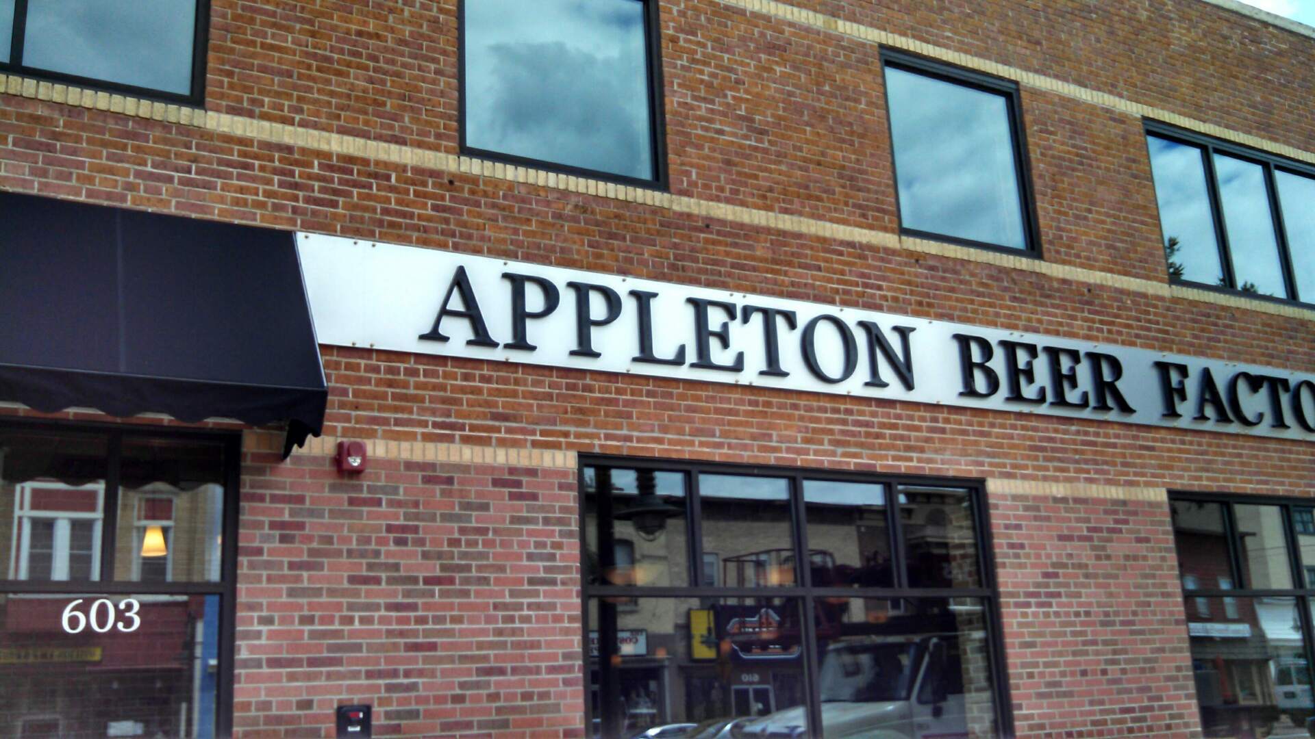 A brick building with a sign that says appleton beer factory