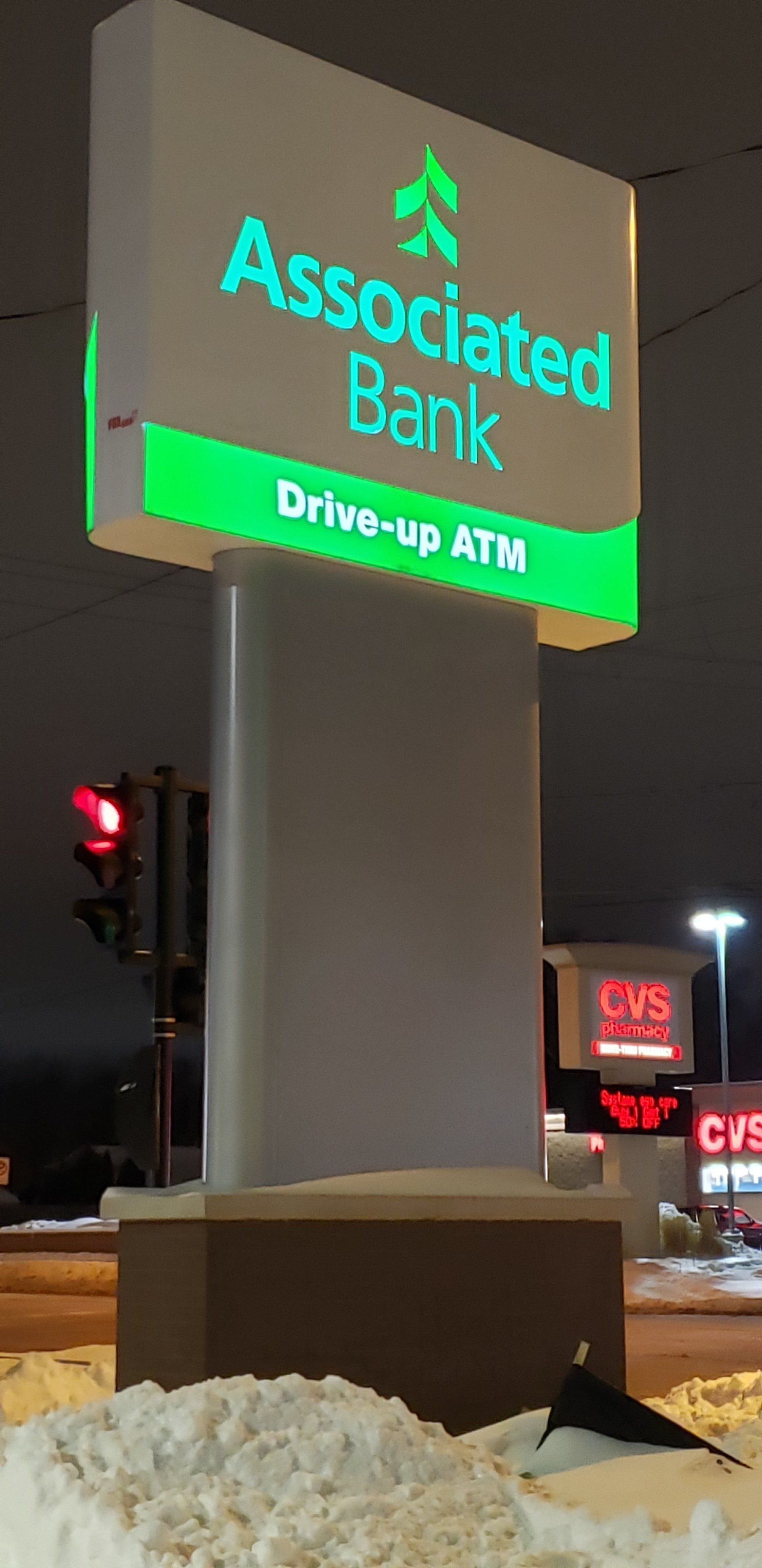 A sign for the associated bank is lit up at night