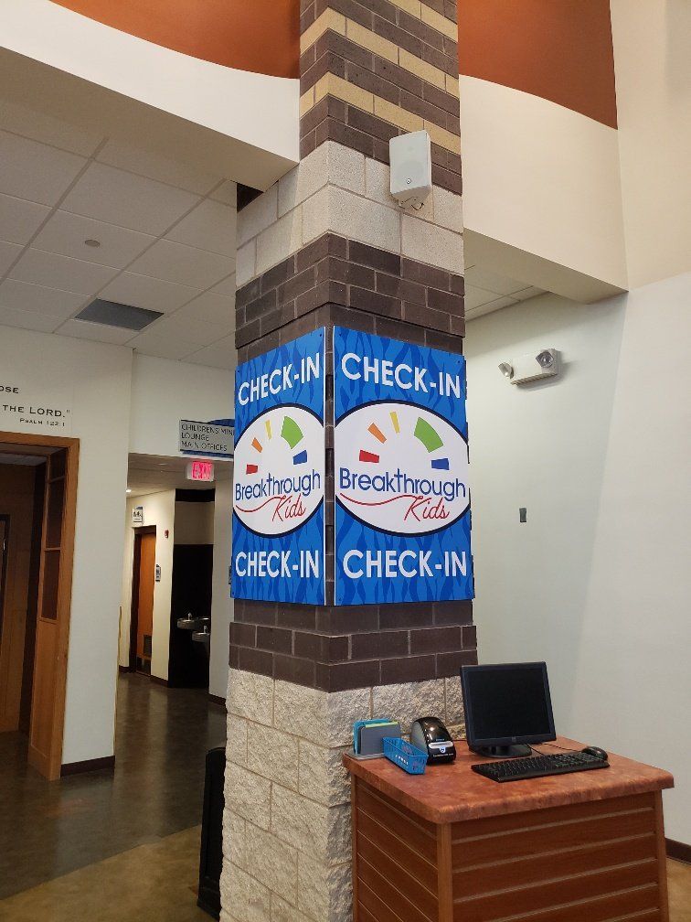 A brick column with check-in signs on it