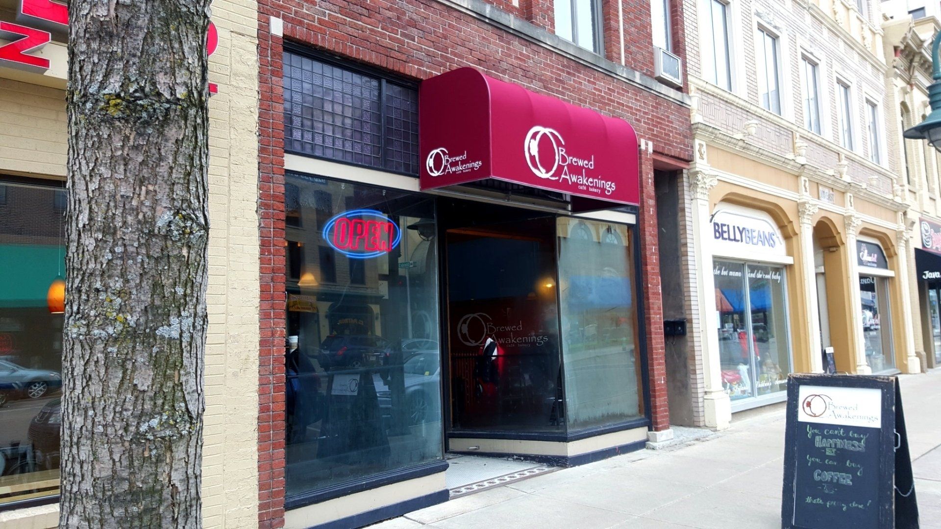 A restaurant with a red awning on the front of it.