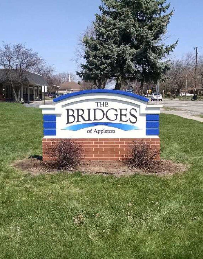 A blue and white sign for the bridges of appleton