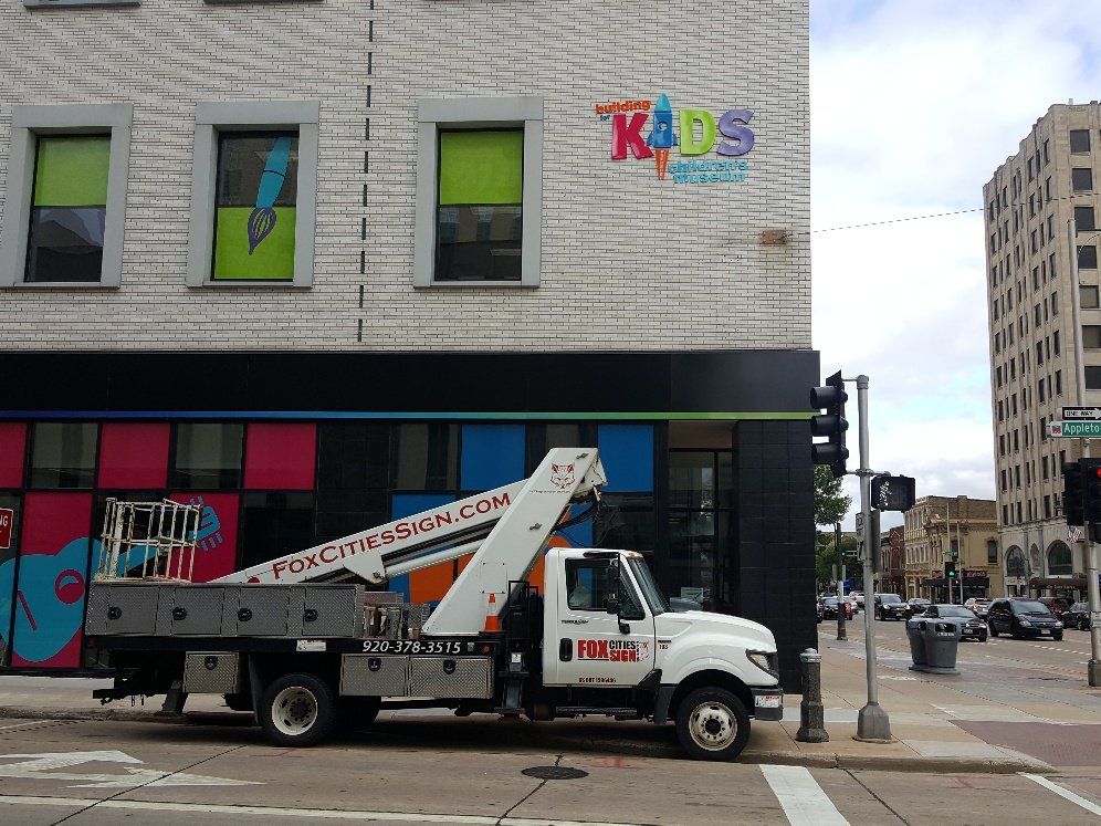 A truck is parked in front of a building that says kids