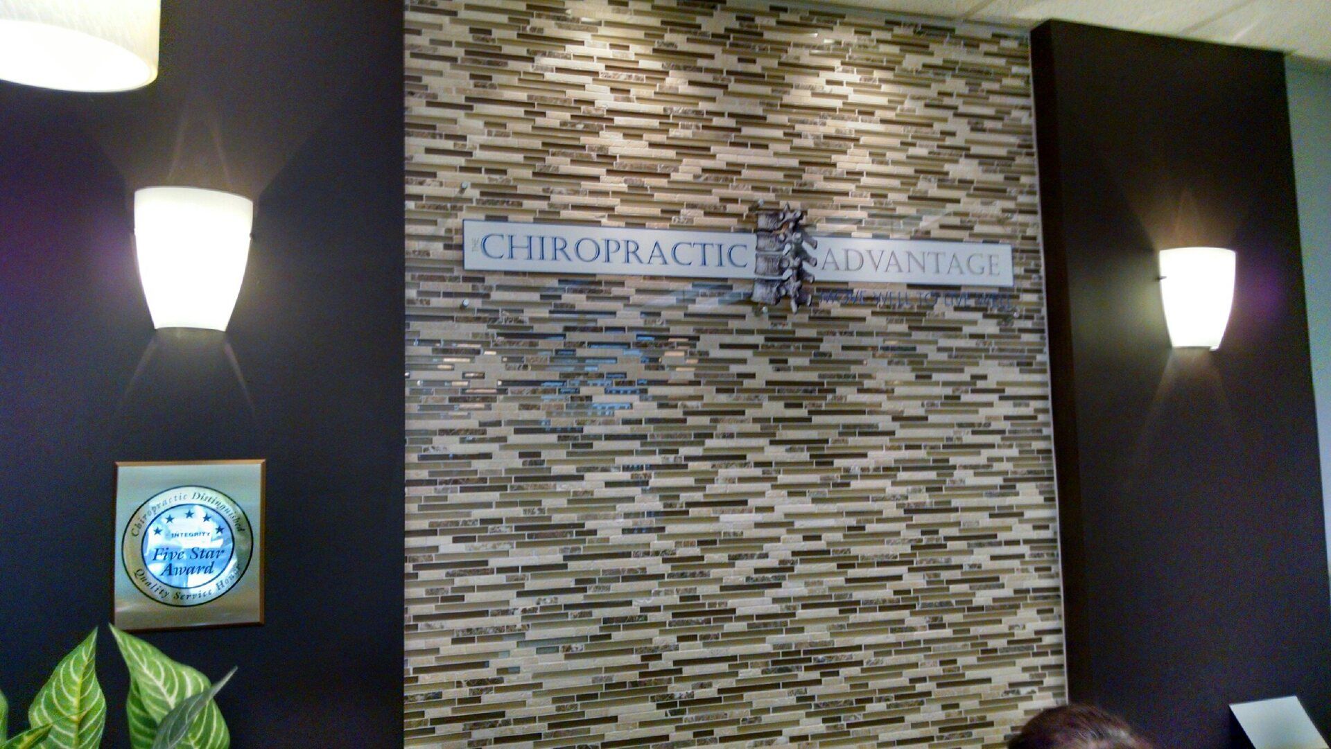 A stone wall with a sign that says chiropractic advantage