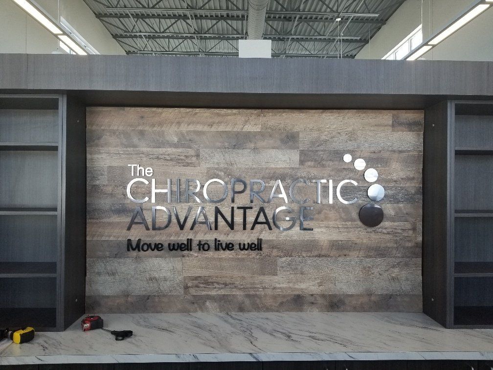 A wooden wall with a sign that says the chiropractic advantage