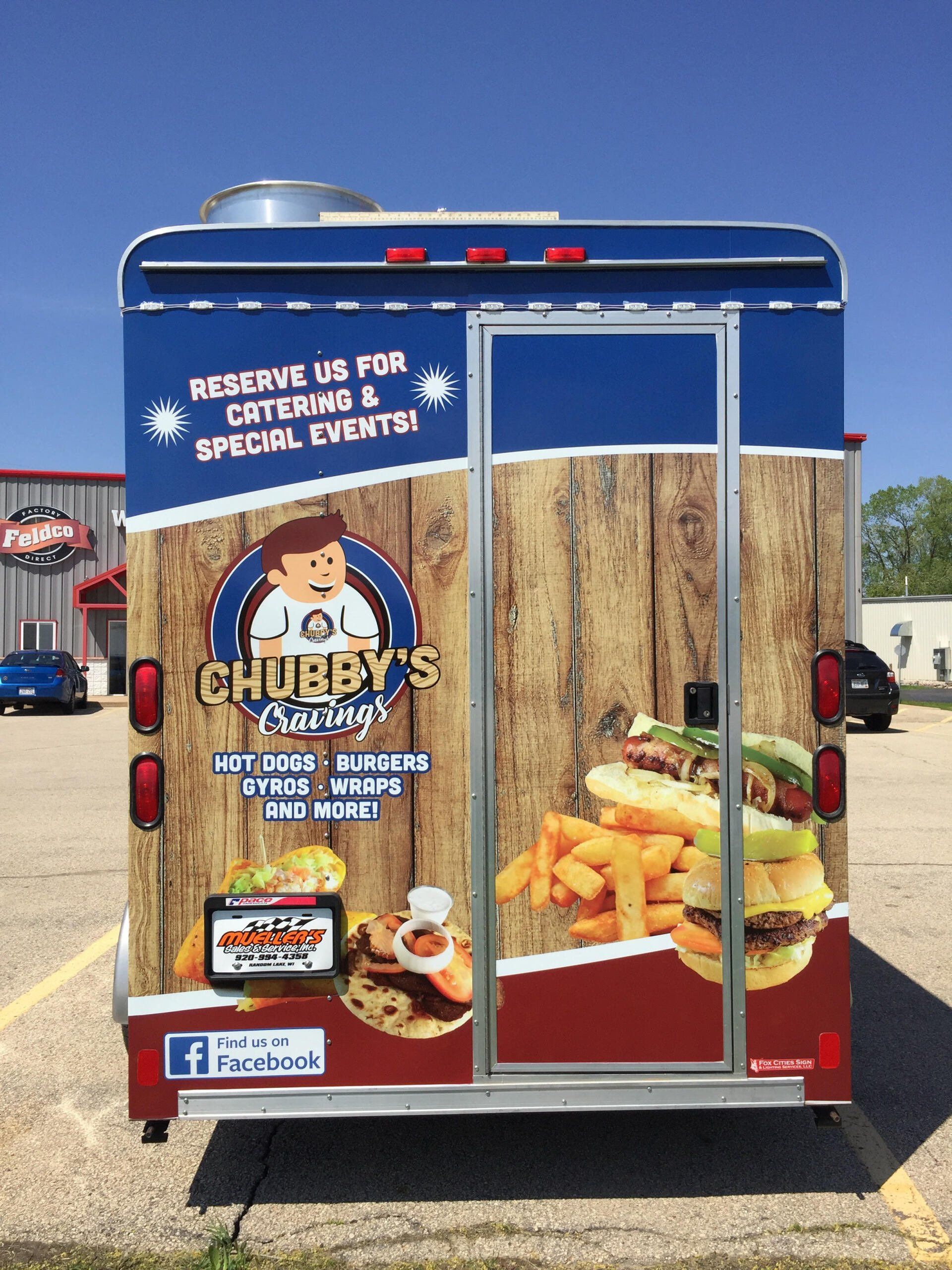 A food truck is parked in a parking lot advertising chubby 's