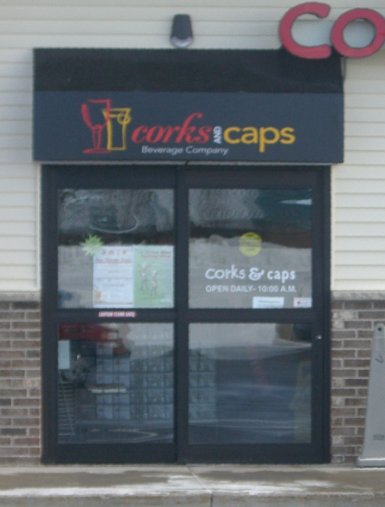 A store front with a sign that says corks & caps