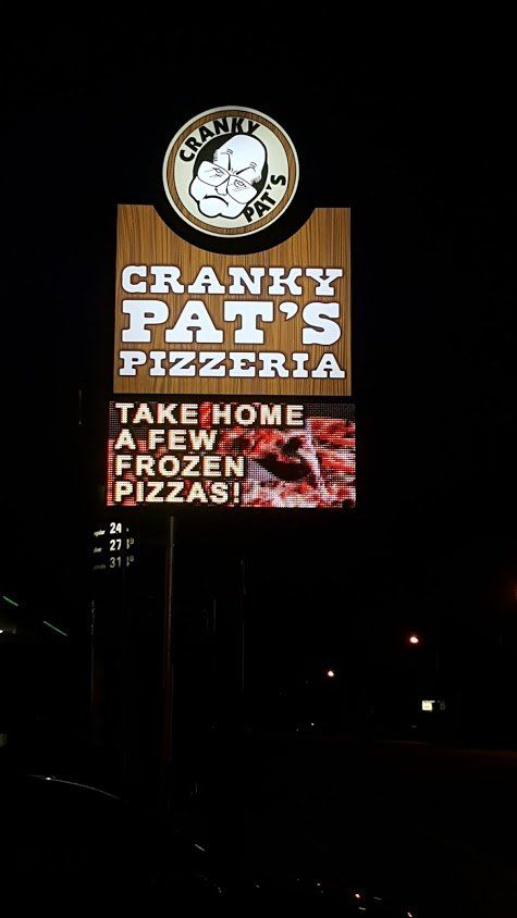 A sign for cranky pat 's pizzeria that says take home a few frozen pizzas