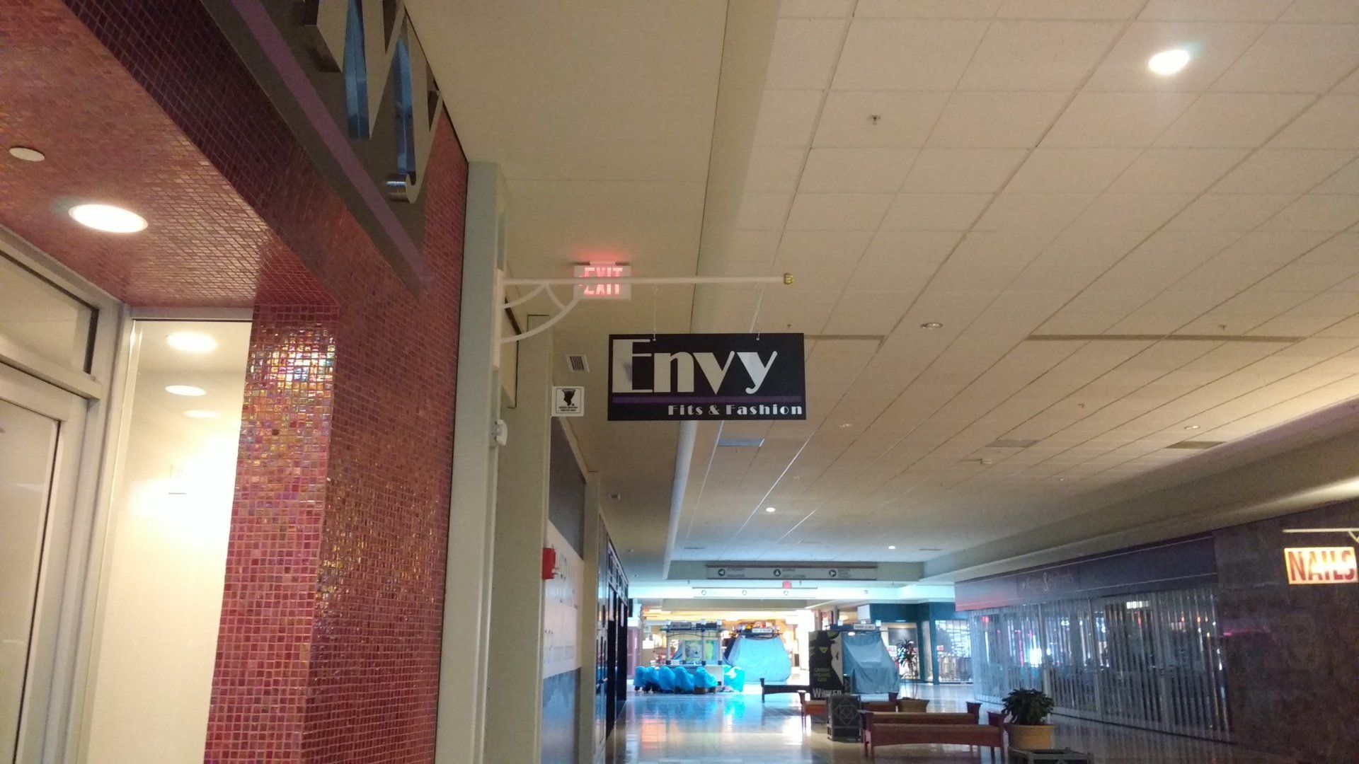 A sign that says envy hangs from the ceiling of a building