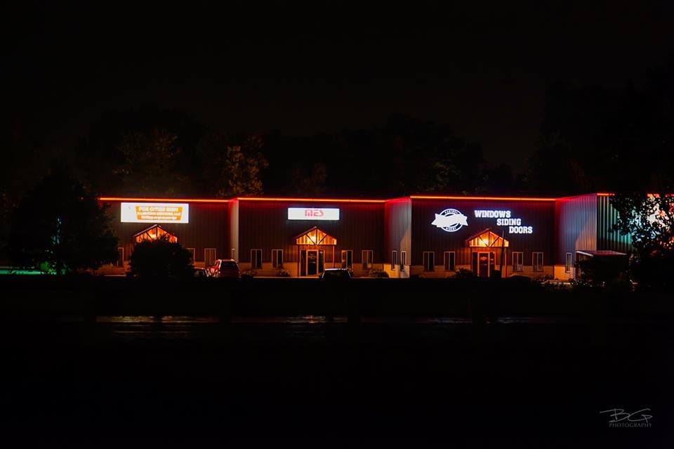 A large building is lit up at night with red lights.