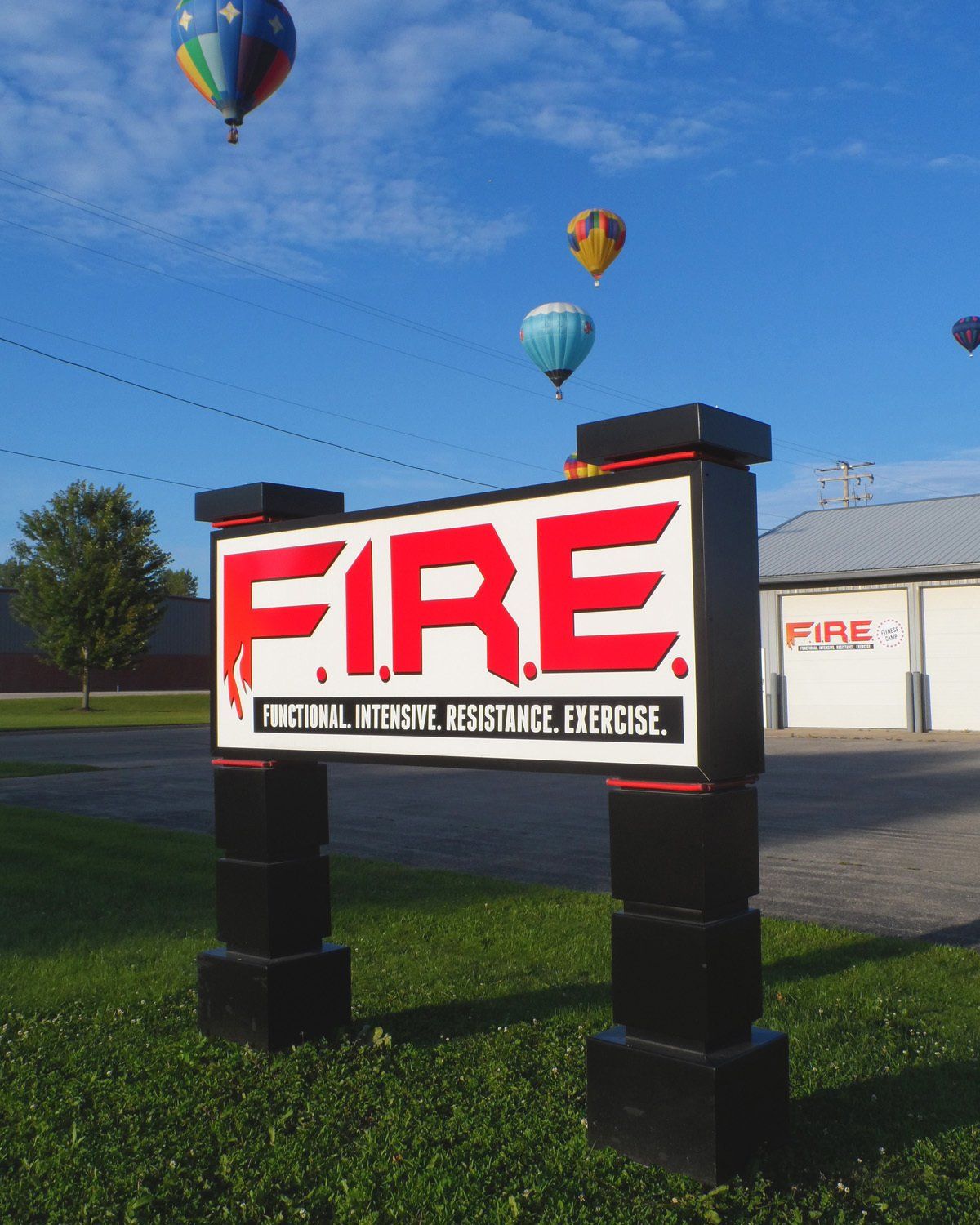 A fire sign with hot air balloons in the background