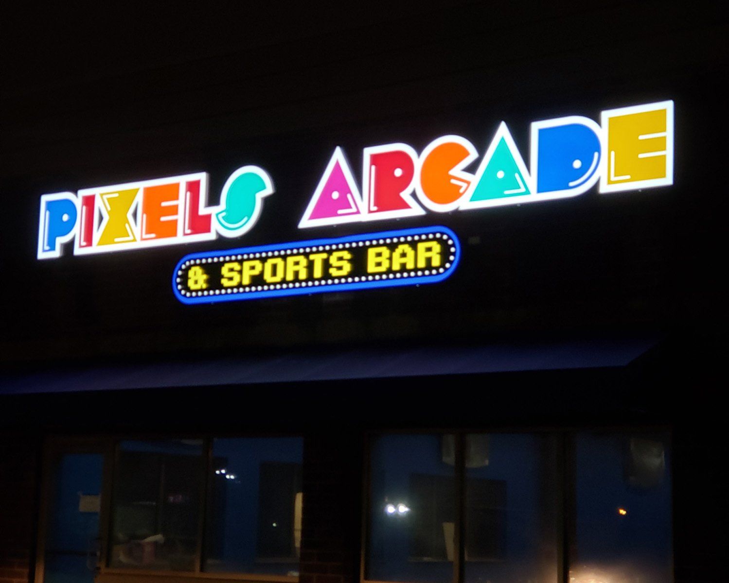 A neon sign for pixel 's arcade and sports bar