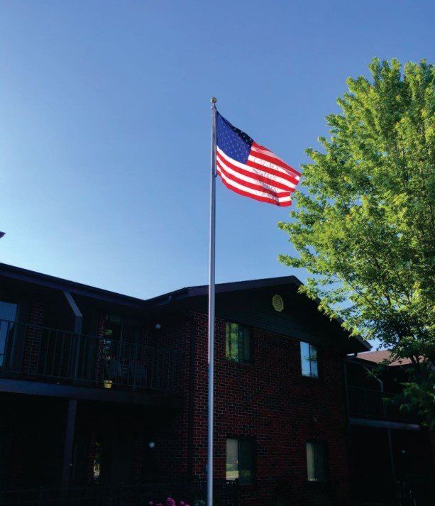 An american flag is flying in front of a brick building