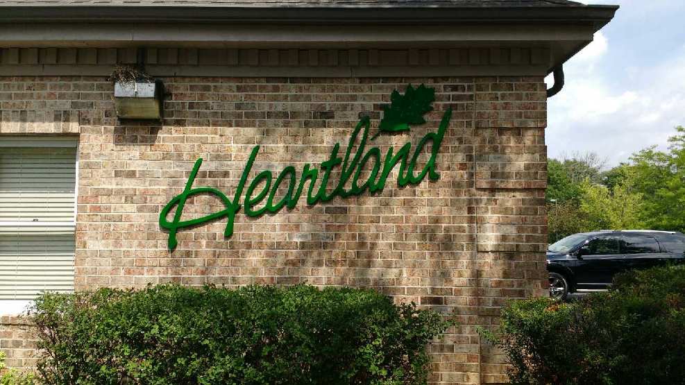 A brick building with a green sign that says heartland