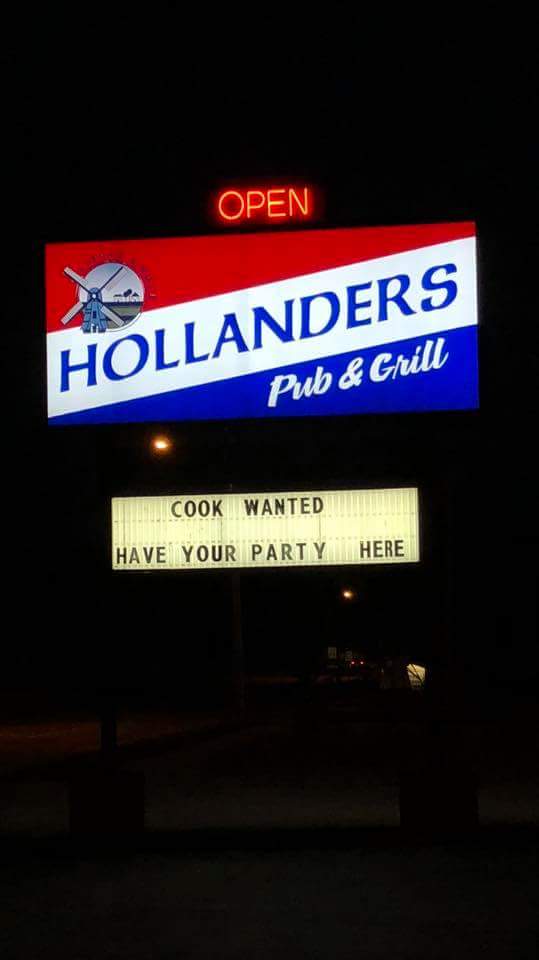 A sign for hollanders pub and grill is lit up at night