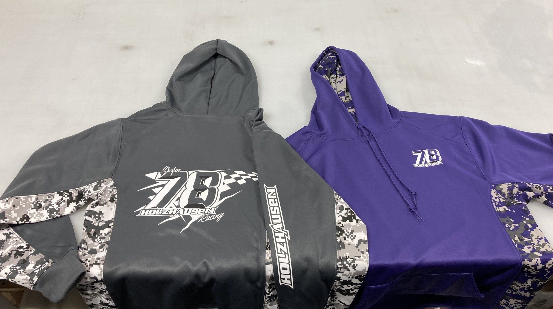 A purple hoodie and a gray hoodie are on a table