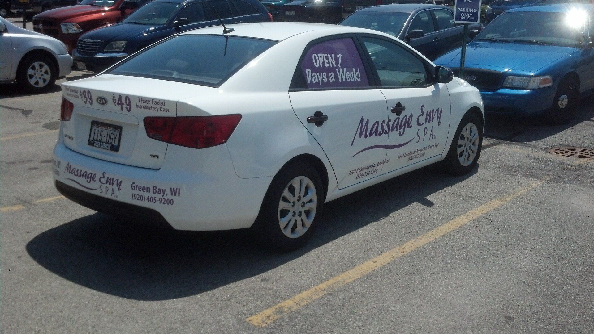 A white massage car is parked in a parking lot