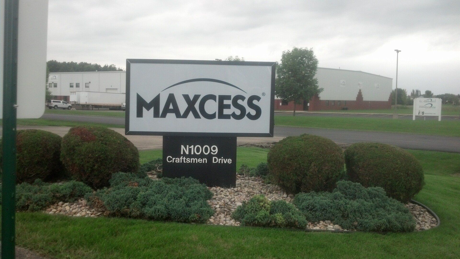 A sign that says maxcess in front of a building