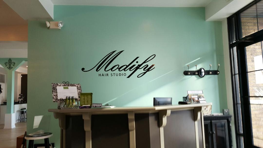 A sign on a wall that says ' modify ' on it