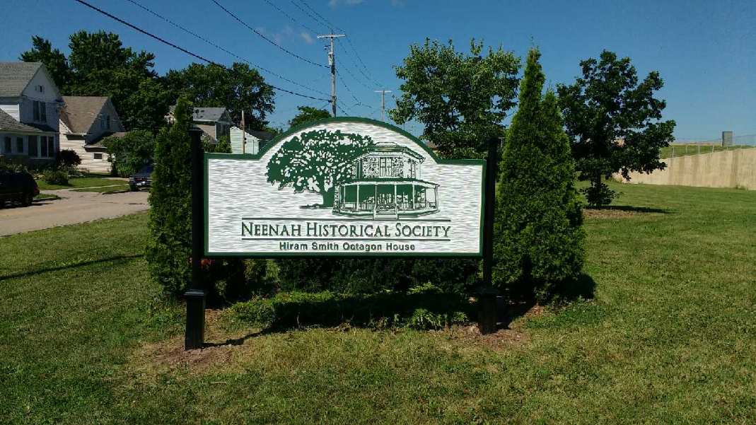 A sign is sitting in the middle of a grassy field.