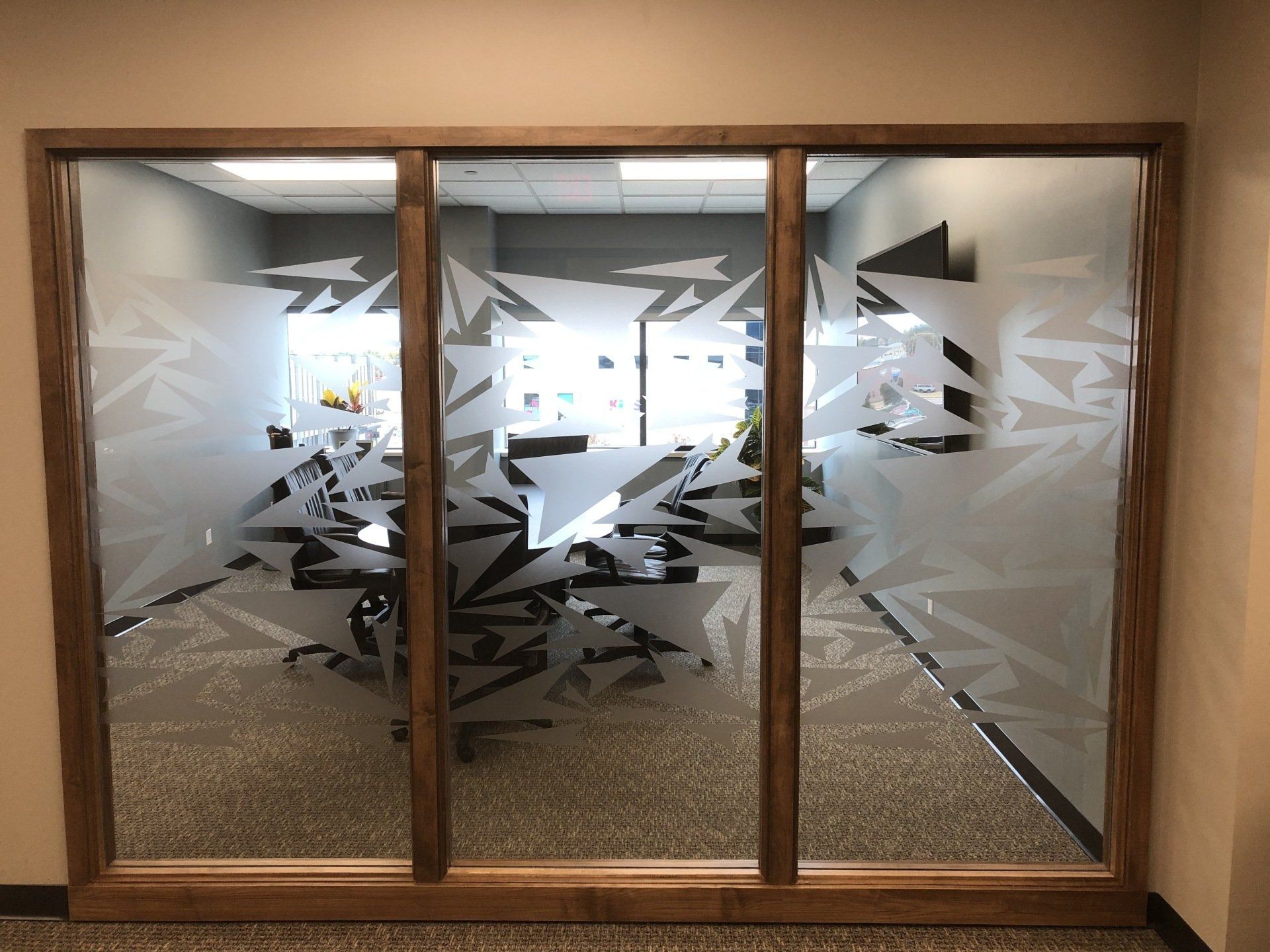 A conference room with sliding glass doors and a wooden frame.