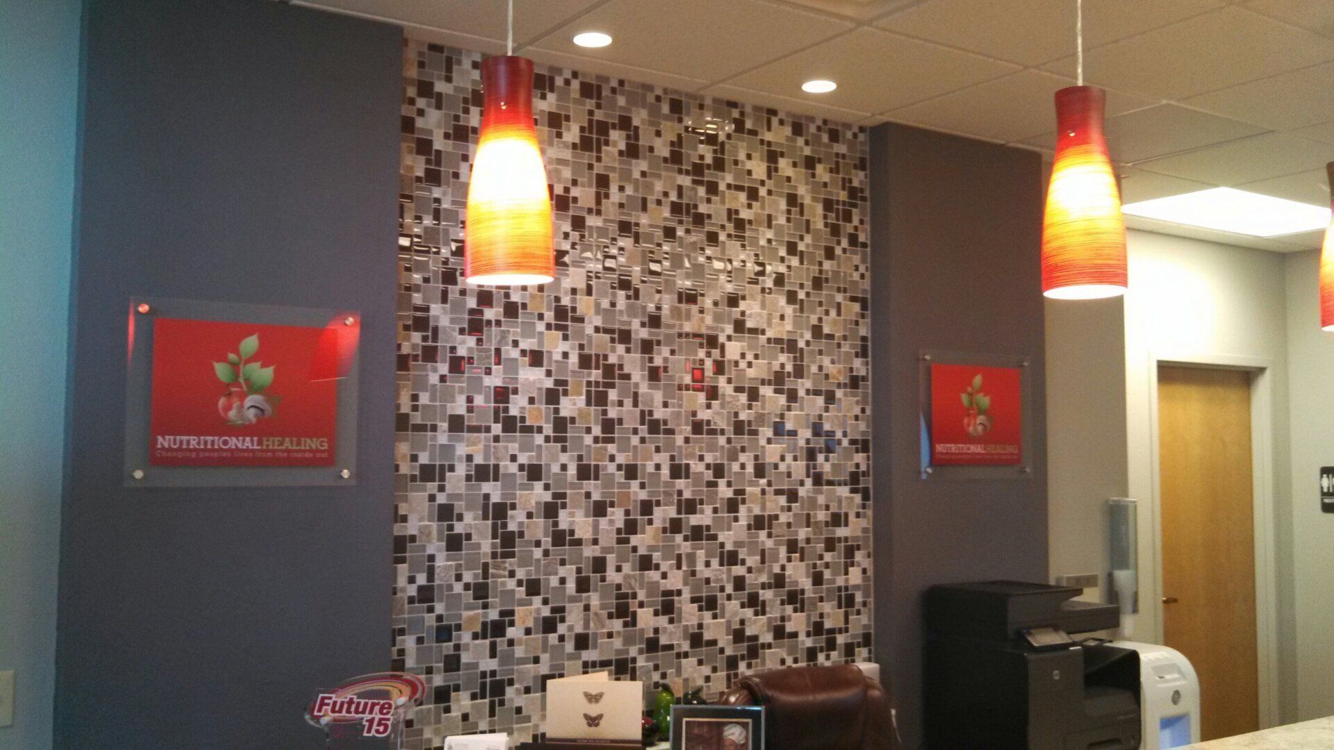 A reception area with a mosaic wall and hanging lights