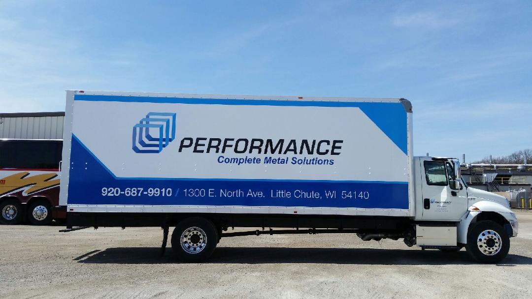 A blue and white performance truck is parked in a parking lot.