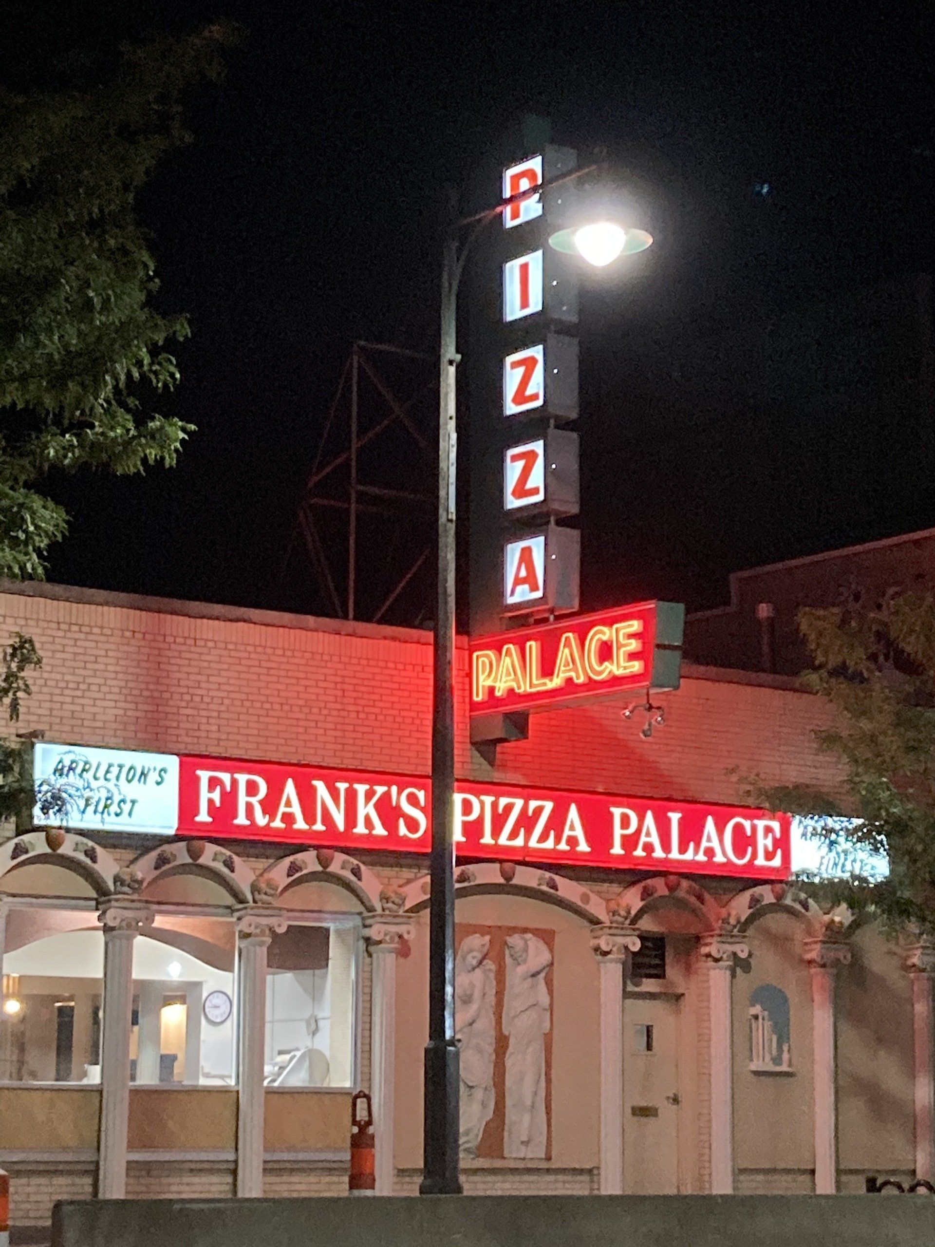 Frank 's pizza palace is lit up at night