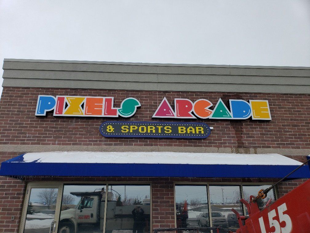 A brick building with a sign that says pixels arcade and sports bar