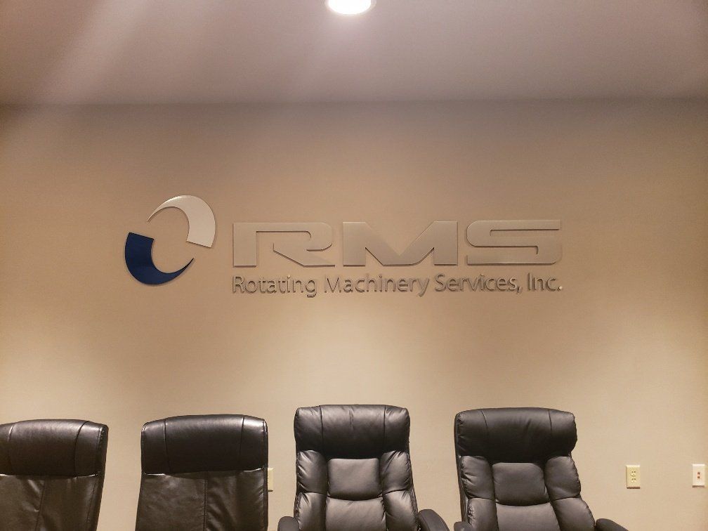 A conference room with chairs and a sign that says rms rotating machinery services inc.
