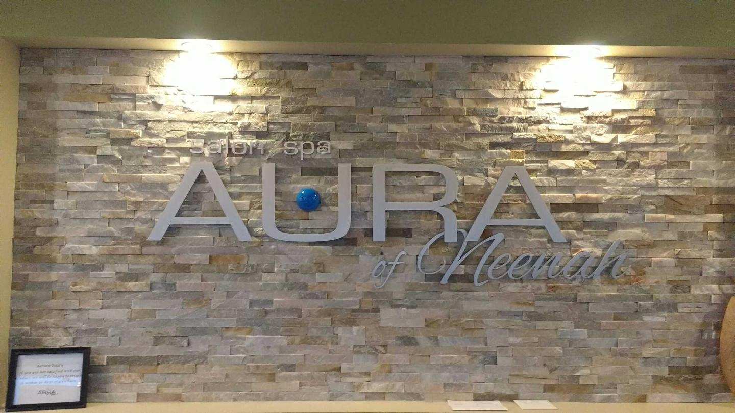 A brick wall with a sign that says aura on it