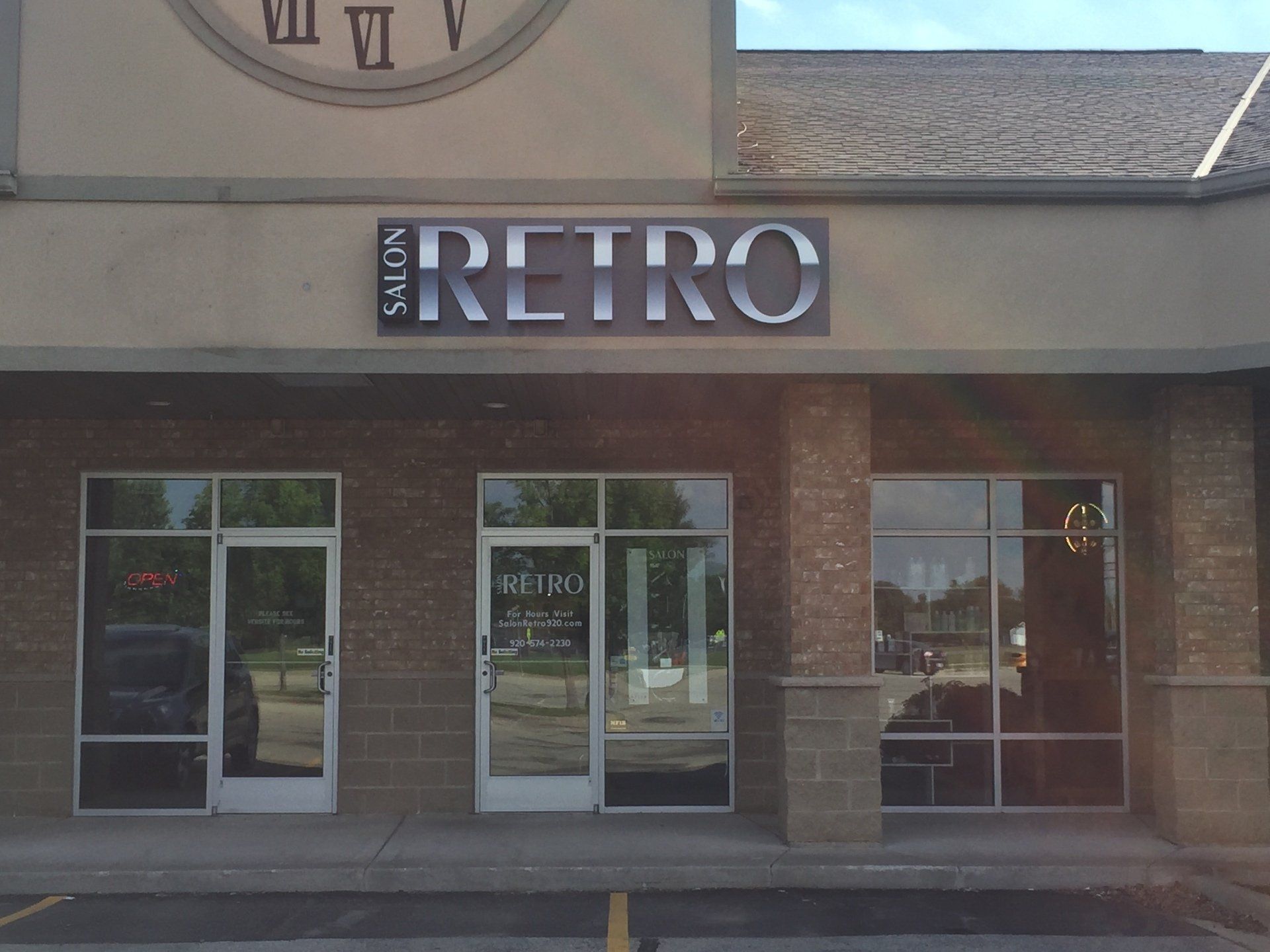 The front of a retro salon with a clock above it