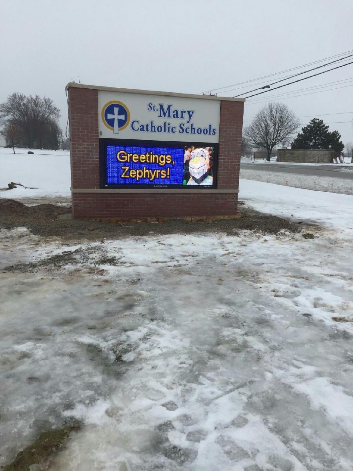 A sign for st. mary catholic school in the snow