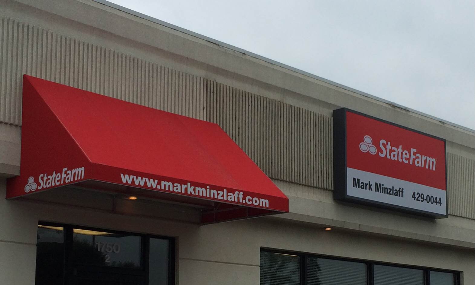 A red awning on the side of a building that says state farm
