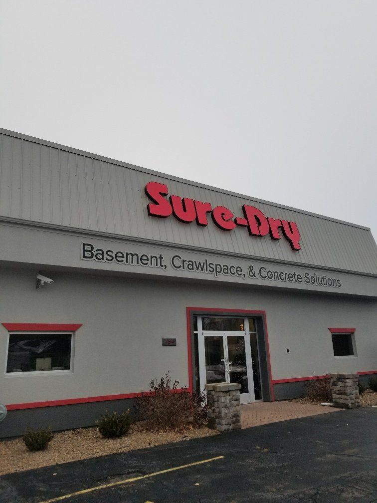 A building that says sure-dry basement crewspace and concrete solutions