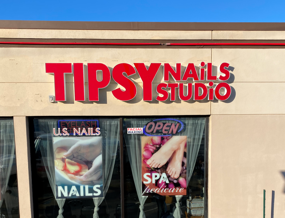 The front of a nail salon called tipsy nails studio.