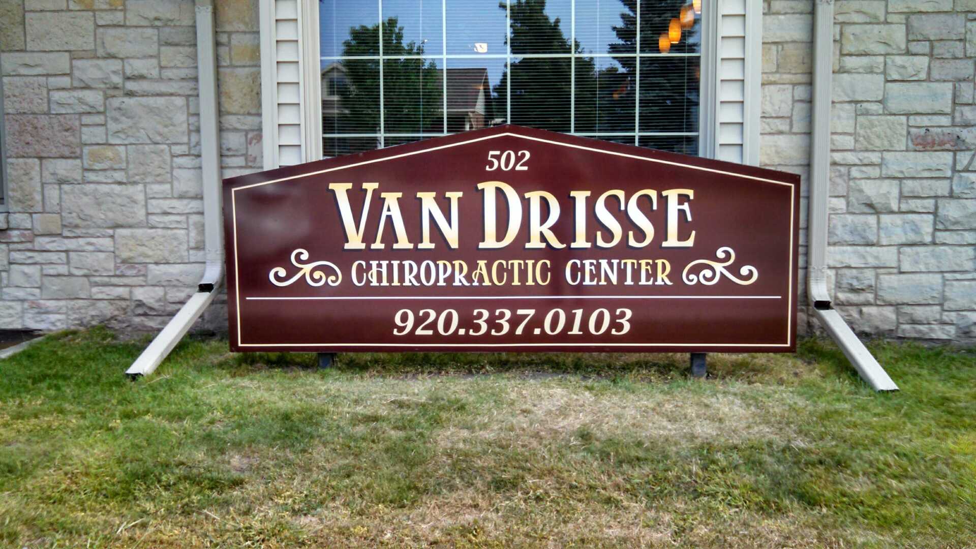 A wooden sign for van drosse chiropractic center
