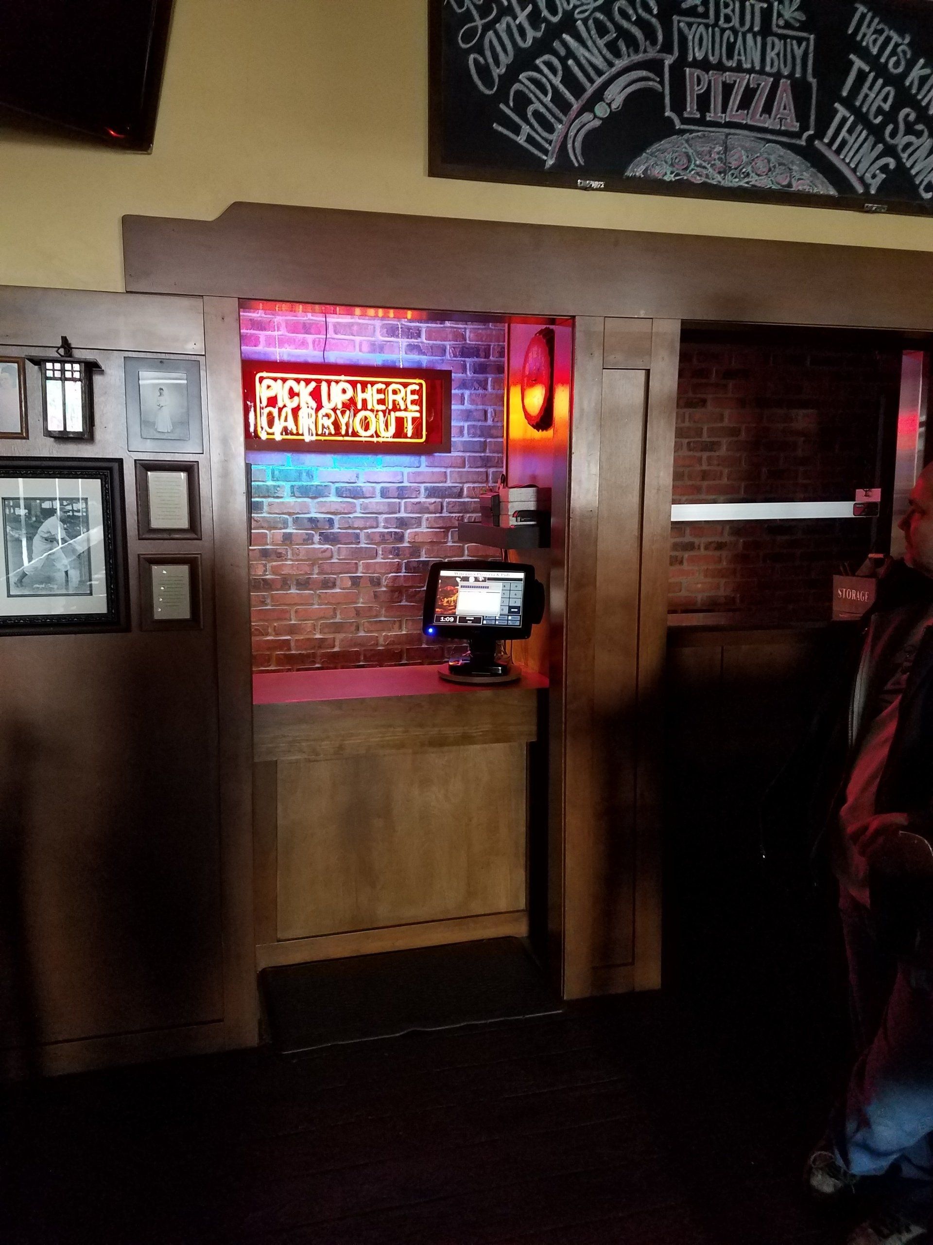 A man standing in front of a sign that says pizza